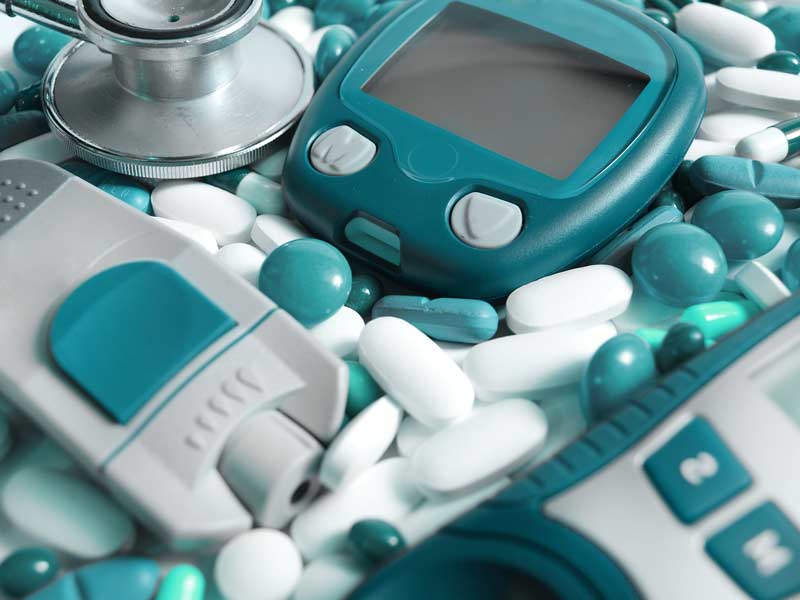 Medical devices surrounded by green and white pills